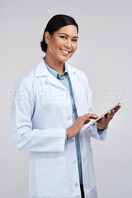 Buy stock photo Cropped portrait of an attractive young female scientist using a tablet in studio against a grey background