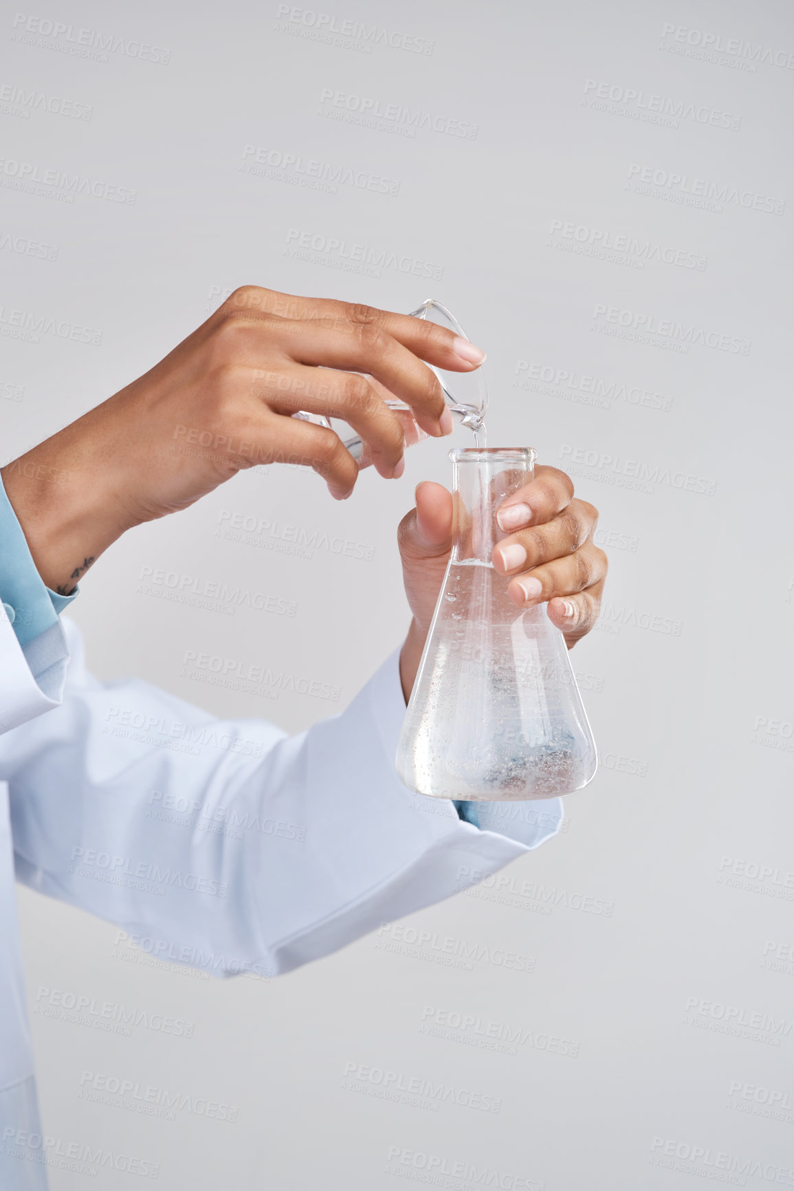 Buy stock photo Cropped shot of an unrecognizable female scientist mixing samples in studio against a grey background