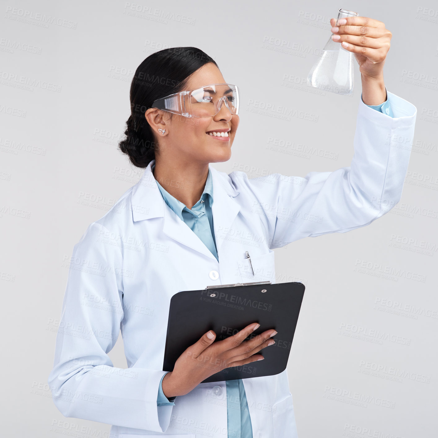 Buy stock photo Cropped shot of an attractive young female scientist examining a beaker filled with liquid in studio against a grey background