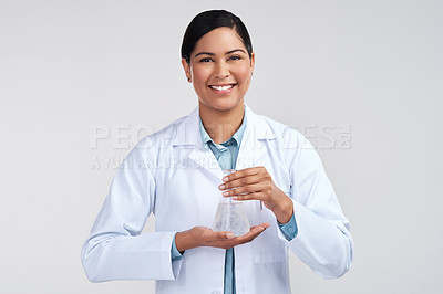 Buy stock photo Cropped portrait of an attractive young female scientist holding a beaker filled with liquid in studio against a grey background