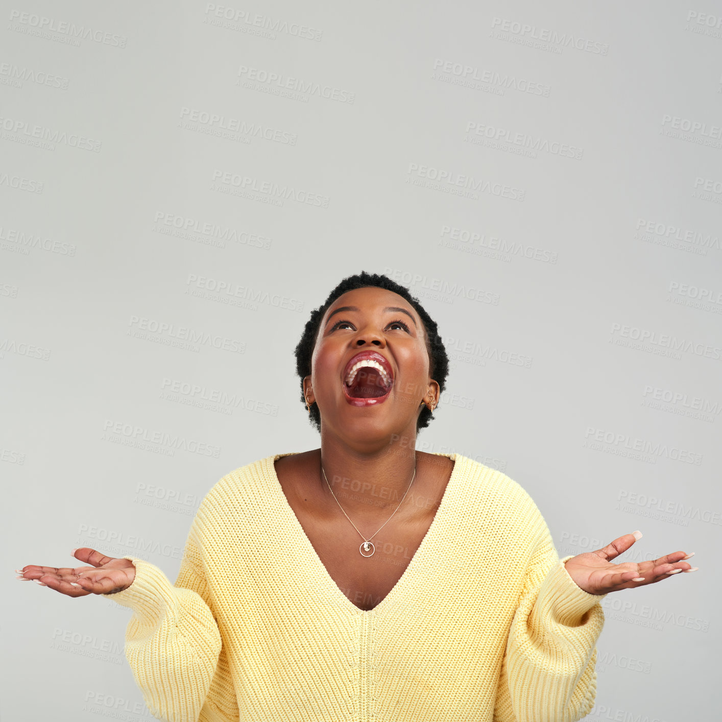 Buy stock photo Shot of a young woman holding up her hands while standing against a grey background