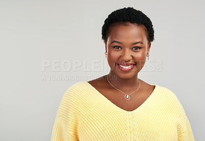 Buy stock photo Shot of a beautiful young woman smiling while posing against a grey background