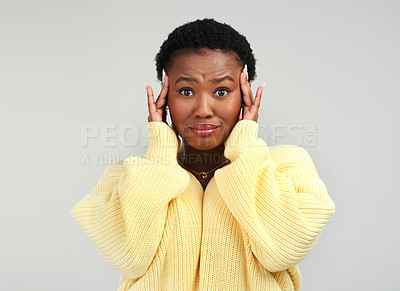 Buy stock photo Shot of a young woman looking worried while posing against a grey background