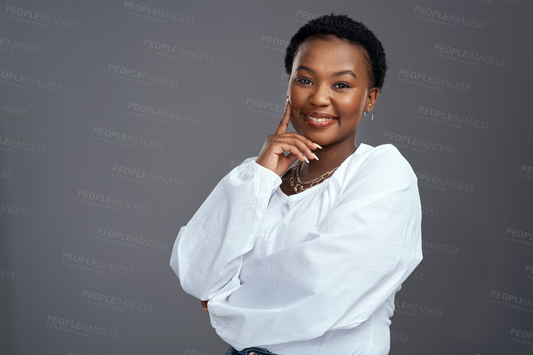 Buy stock photo Shot of a beautiful young woman smiling while posing against a grey background