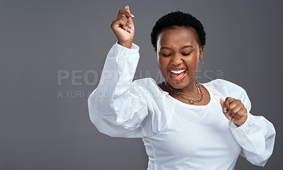 Buy stock photo Shot of a beautiful young woman dancing against a grey background