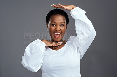 Buy stock photo Shot of a beautiful young woman framing her face with her hands while posing against a grey background