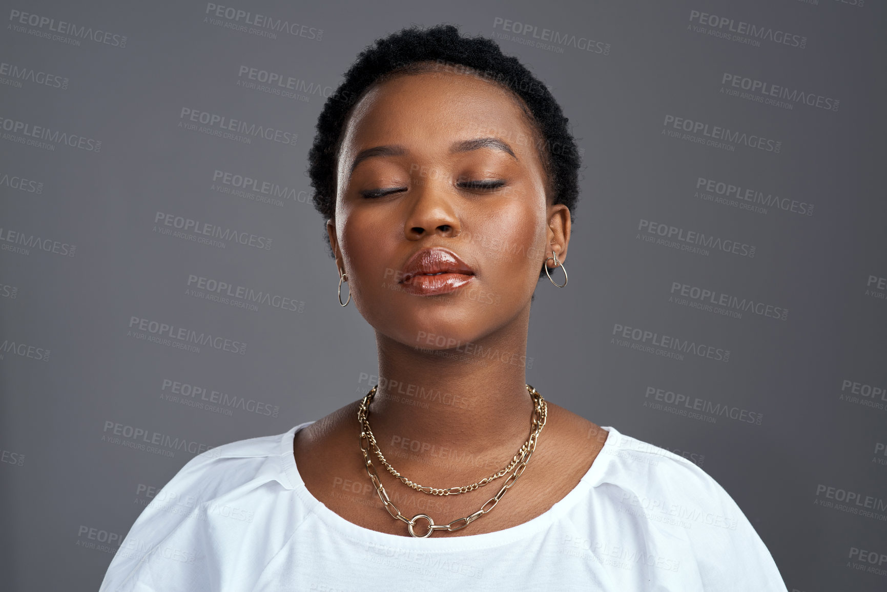 Buy stock photo Shot of a beautiful young woman posing against a grey background