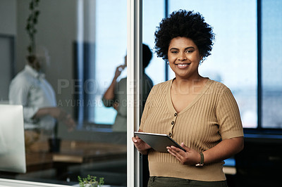 Buy stock photo Shot of an attractive young businesswoman standing in the office and using a digital tablet