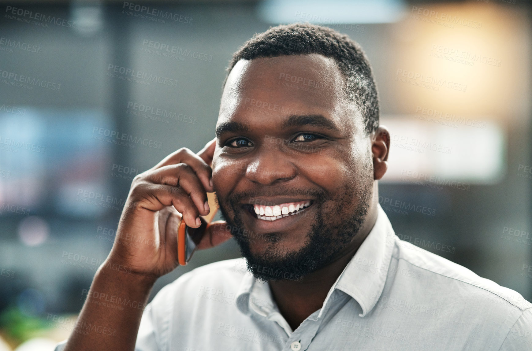 Buy stock photo Shot of a handsome young businessman standing in the office and using his cellphone
