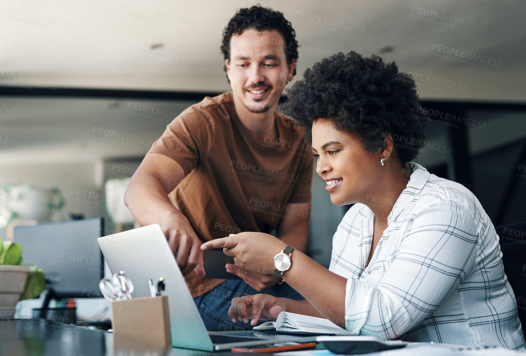 Buy stock photo Shot of two young businesspeople working together in an office