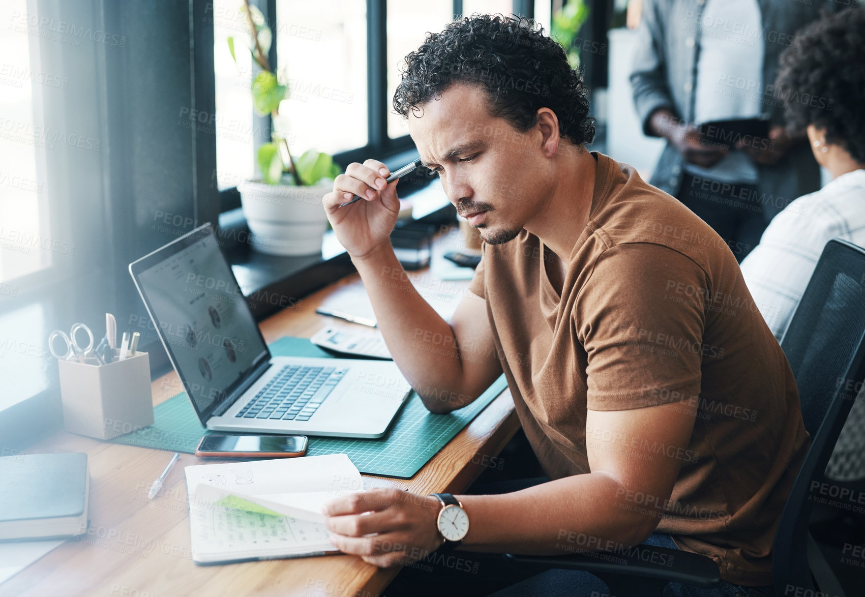 Buy stock photo Shot of a young businessman working in an office