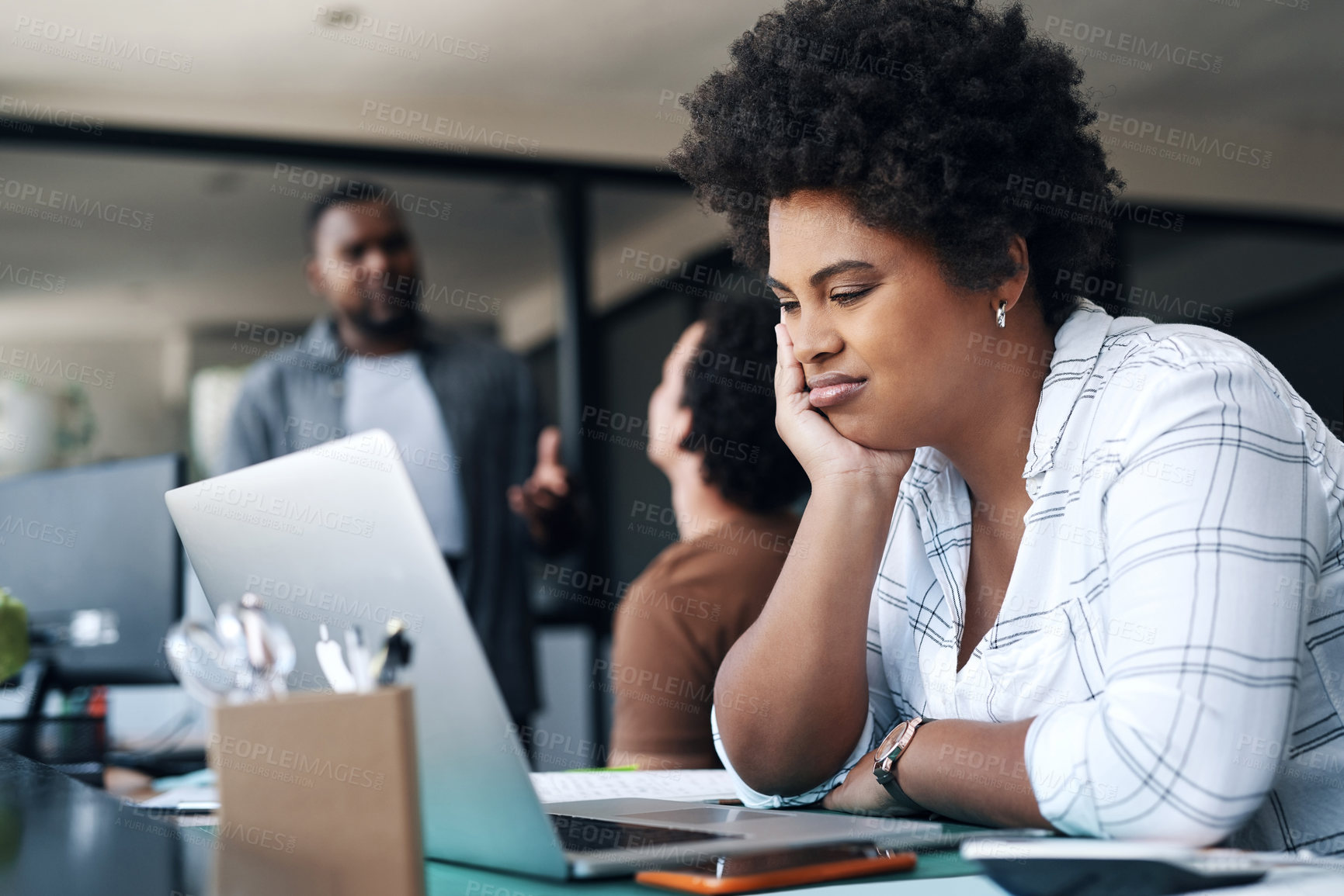 Buy stock photo Shot of a young businesswoman using a laptop and looking annoyed in an office