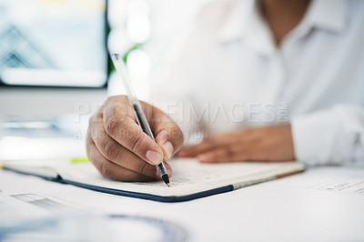 Buy stock photo Shot of an unrecognizable businessperson writing in a notebook in an office