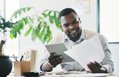 Buy stock photo Shot of a young businessman looking at notes in an office