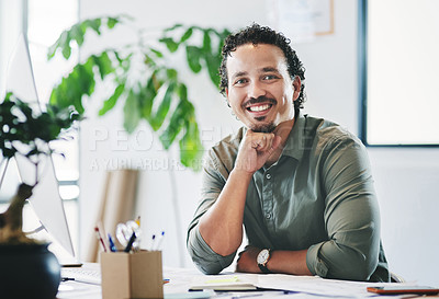 Buy stock photo Shot of a young businessman sitting at a desk in an office