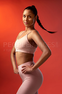Buy stock photo Studio shot of a sporty young woman posing against a red background
