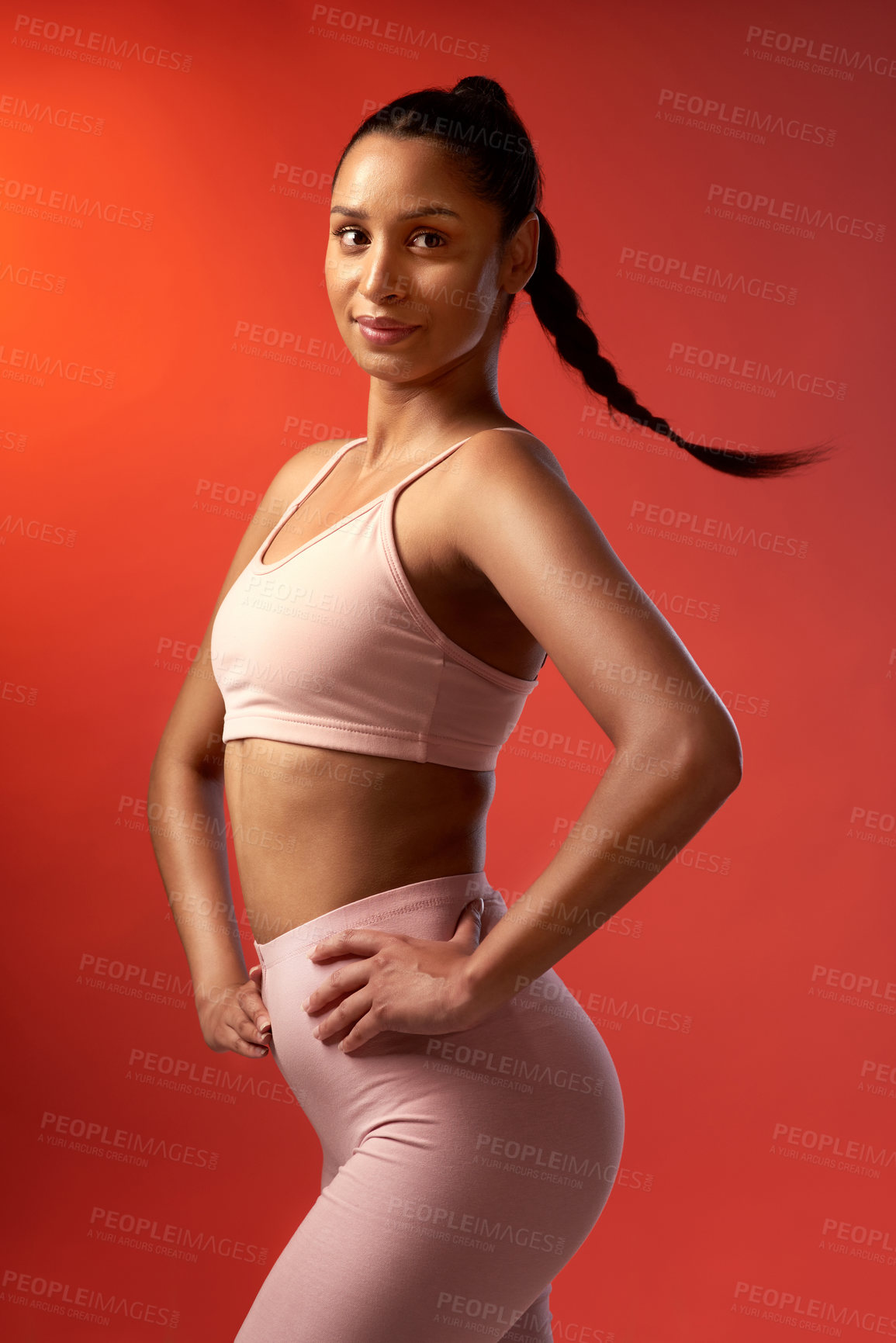 Buy stock photo Studio shot of a sporty young woman posing against a red background