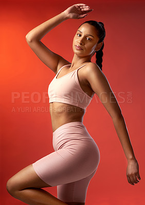 Buy stock photo Studio portrait of a sporty young woman posing against a red background