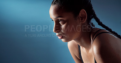 Buy stock photo Studio shot of a sporty young woman catching her breath against a blue background