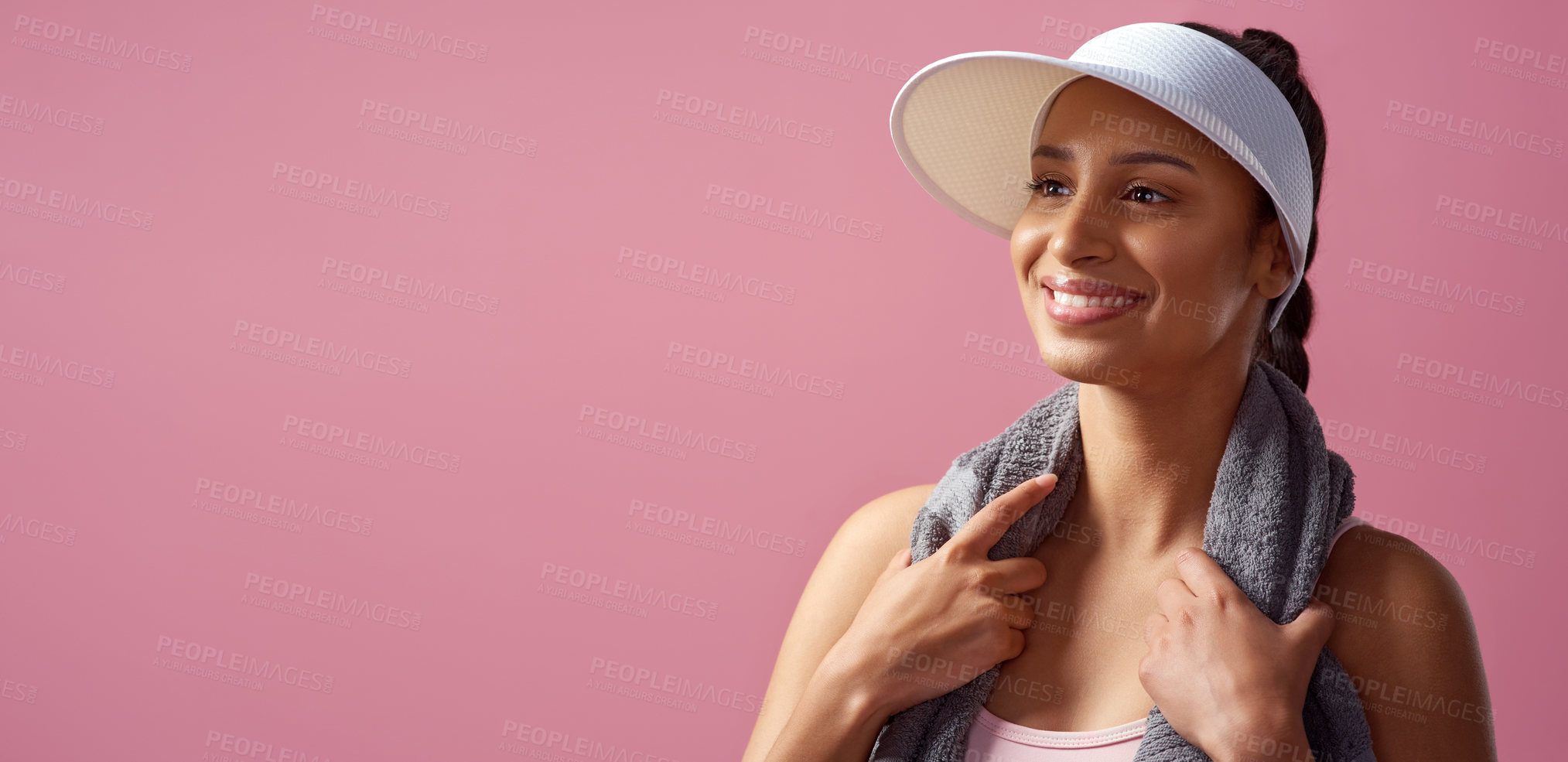 Buy stock photo Cropped shot of an attractive and sporty young woman posing with a towel in studio against a pink background