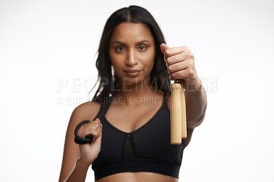 Buy stock photo Studio portrait of a sporty young woman posing with a skipping rope around her neck against a white background