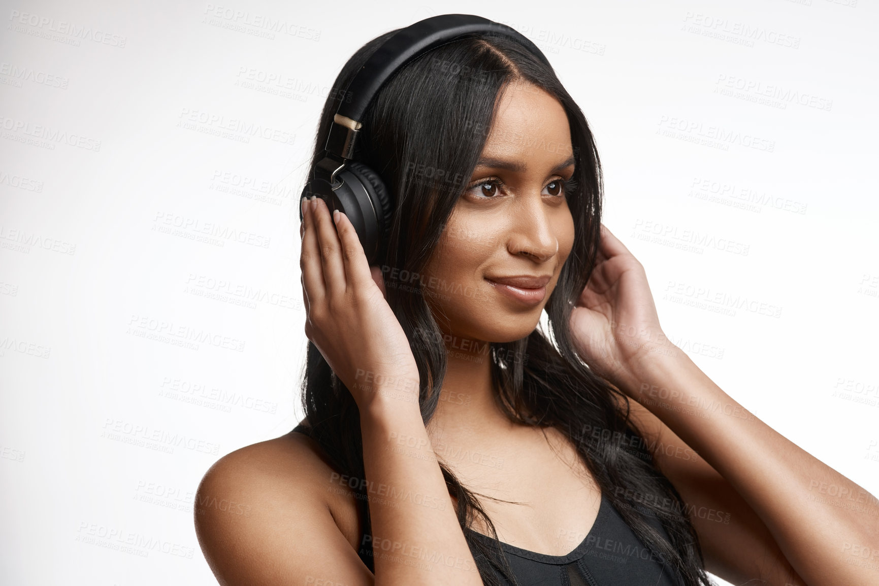 Buy stock photo Studio shot of a sporty young woman listening to music against a white background