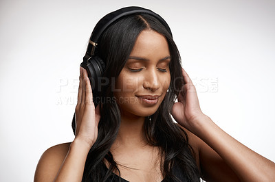 Buy stock photo Studio shot of a sporty young woman listening to music against a white background