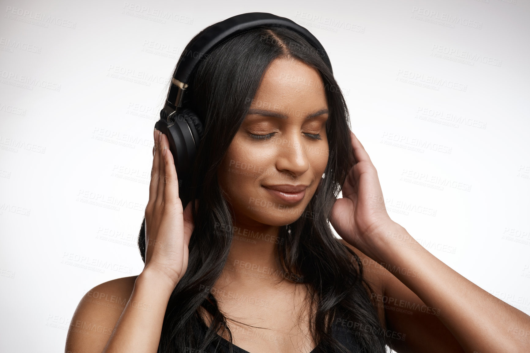 Buy stock photo Studio shot of a sporty young woman listening to music against a white background