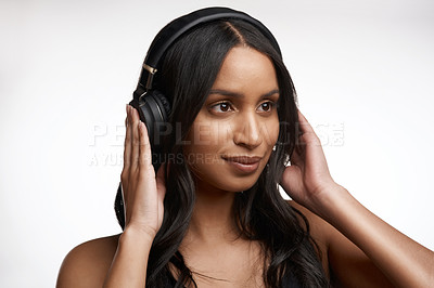 Buy stock photo Studio shot of a sporty young woman listening to music against a white background