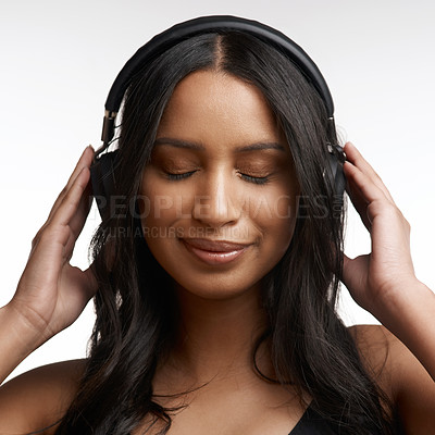 Buy stock photo Studio shot of a sporty young woman listening to music against a white background