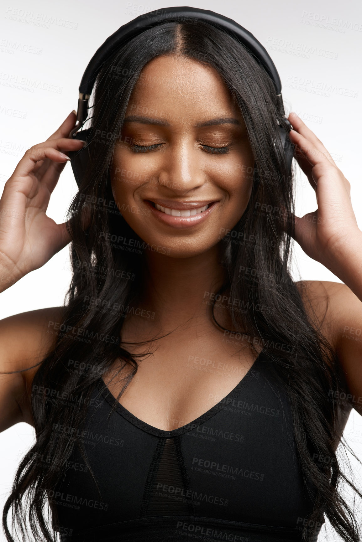 Buy stock photo Studio shot of a sporty young woman listening to music against a white background