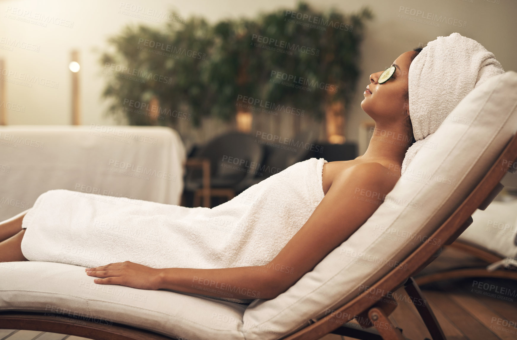 Buy stock photo Shot of a woman relaxing in a spa with cucumber slices on her eyes