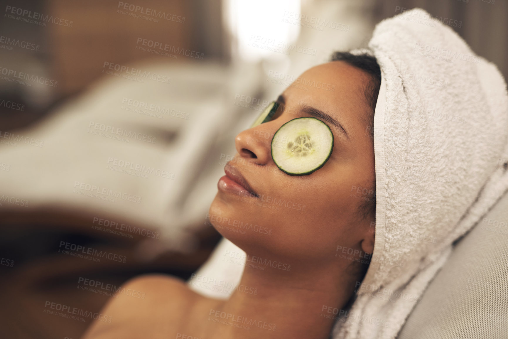 Buy stock photo Shot of a woman relaxing in a spa with cucumber slices on her eyes