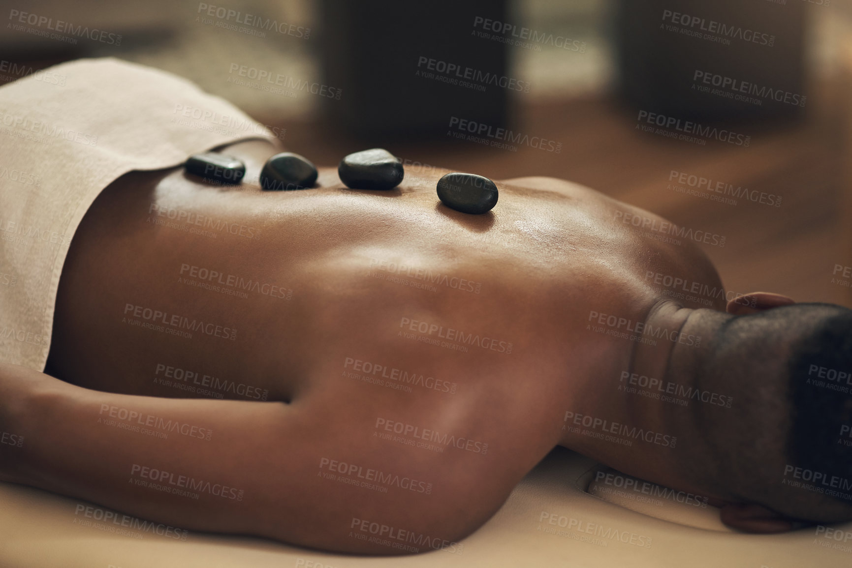 Buy stock photo Cropped shot of a man getting a hot stone massage at a spa