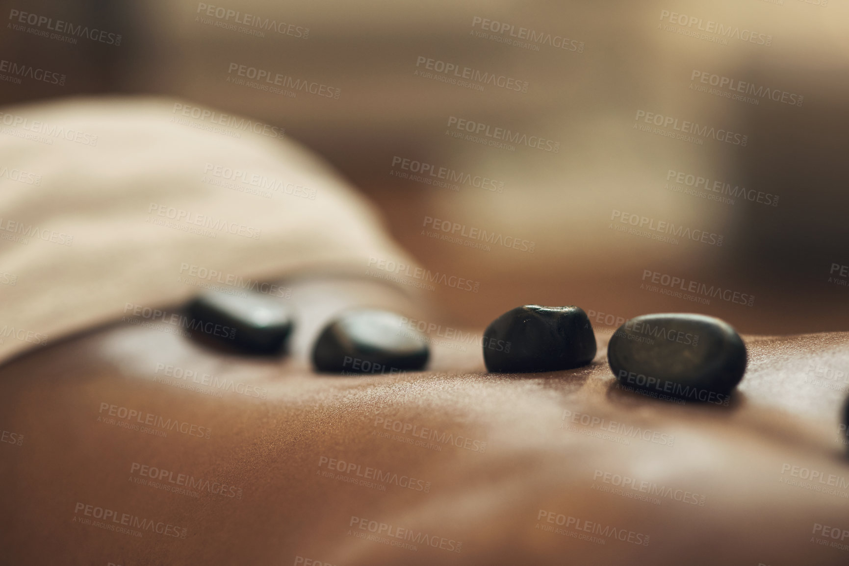 Buy stock photo Cropped shot of a man getting a hot stone massage at a spa