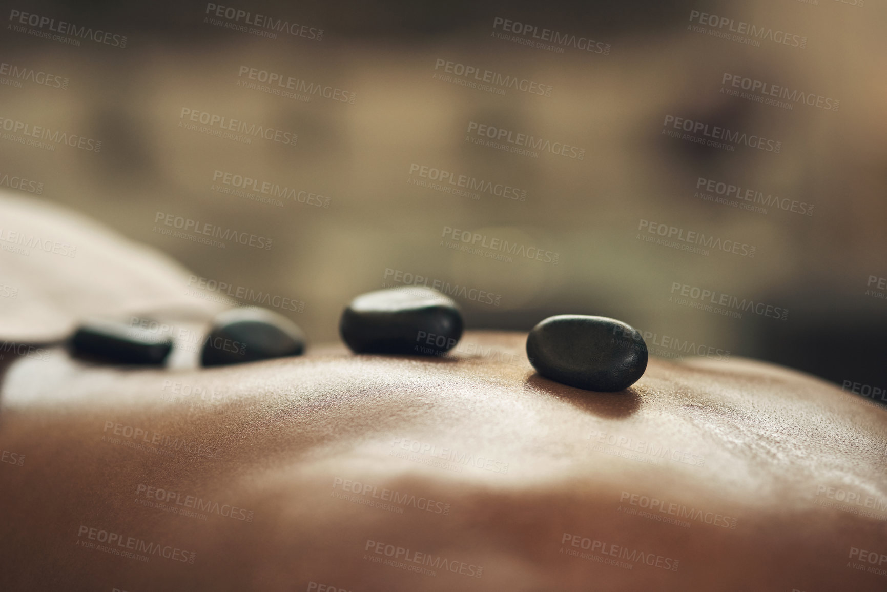 Buy stock photo Cropped shot of a man getting a hot stone massage at a spa