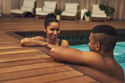 Buy stock photo Shot of a young couple relaxing in a pool at a spa