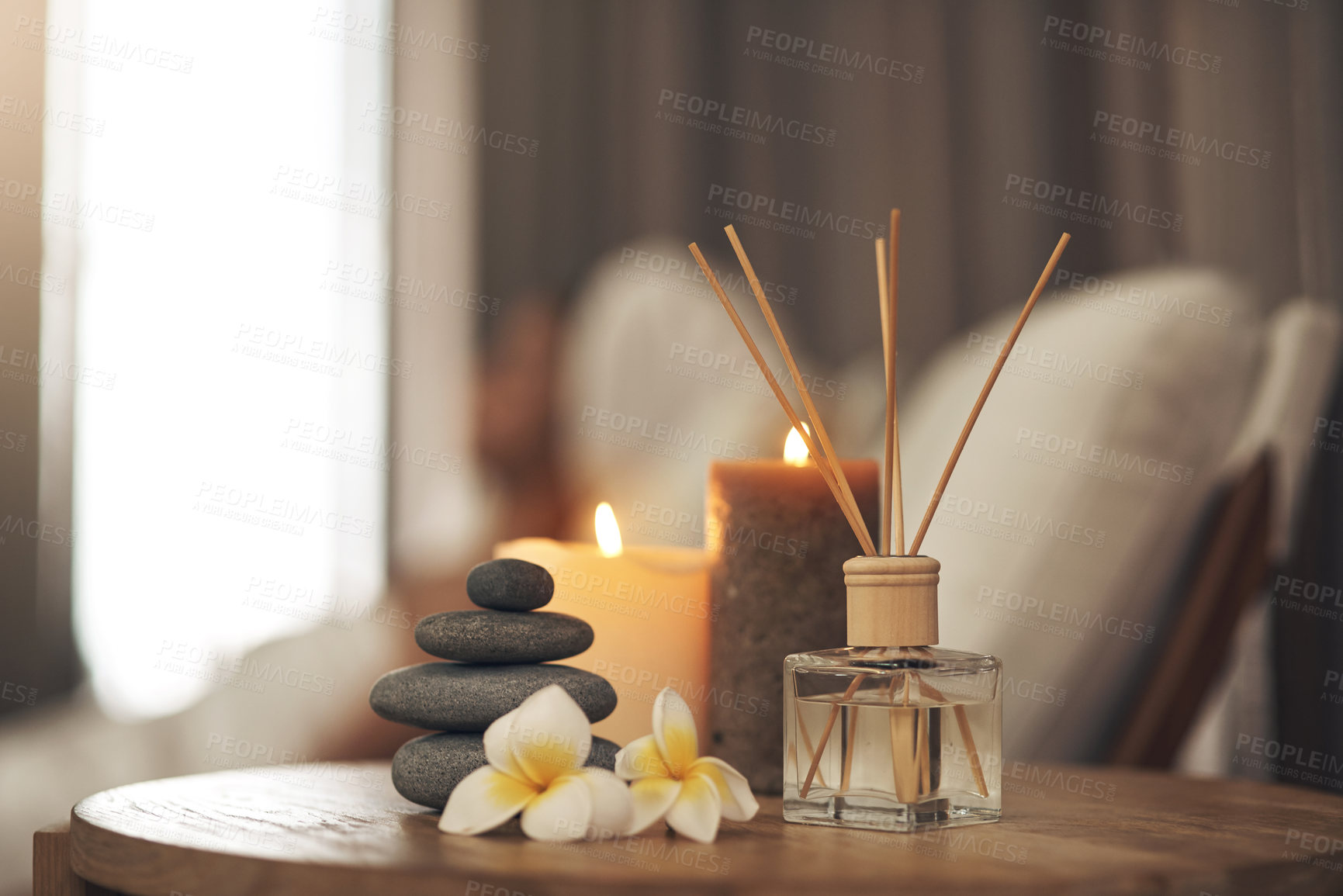 Buy stock photo Spa, aromatherapy and candles on table for zen, calm and peace to relax for health and wellness. Stones, flowers and diffuser for self care, holistic massage and hospitality at a beauty salon