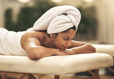 Buy stock photo Shot of a young woman smiling while lying on a massage bed at a spa