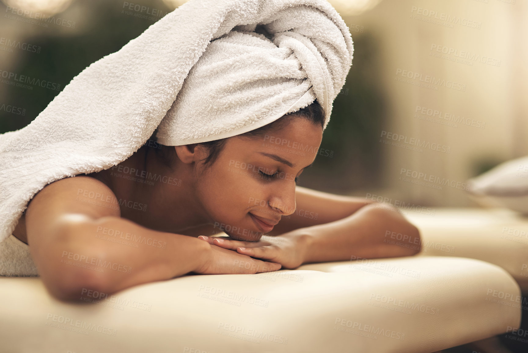 Buy stock photo Shot of a young woman smiling while lying on a massage bed at a spa