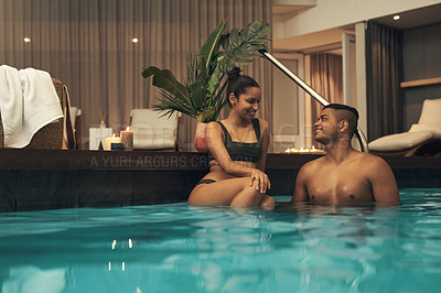 Buy stock photo Shot of a young couple relaxing in a pool at a spa