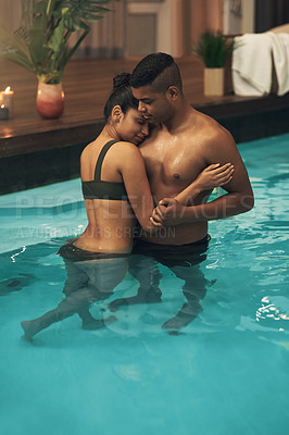 Buy stock photo Shot of a young couple relaxing in a pool at a spa