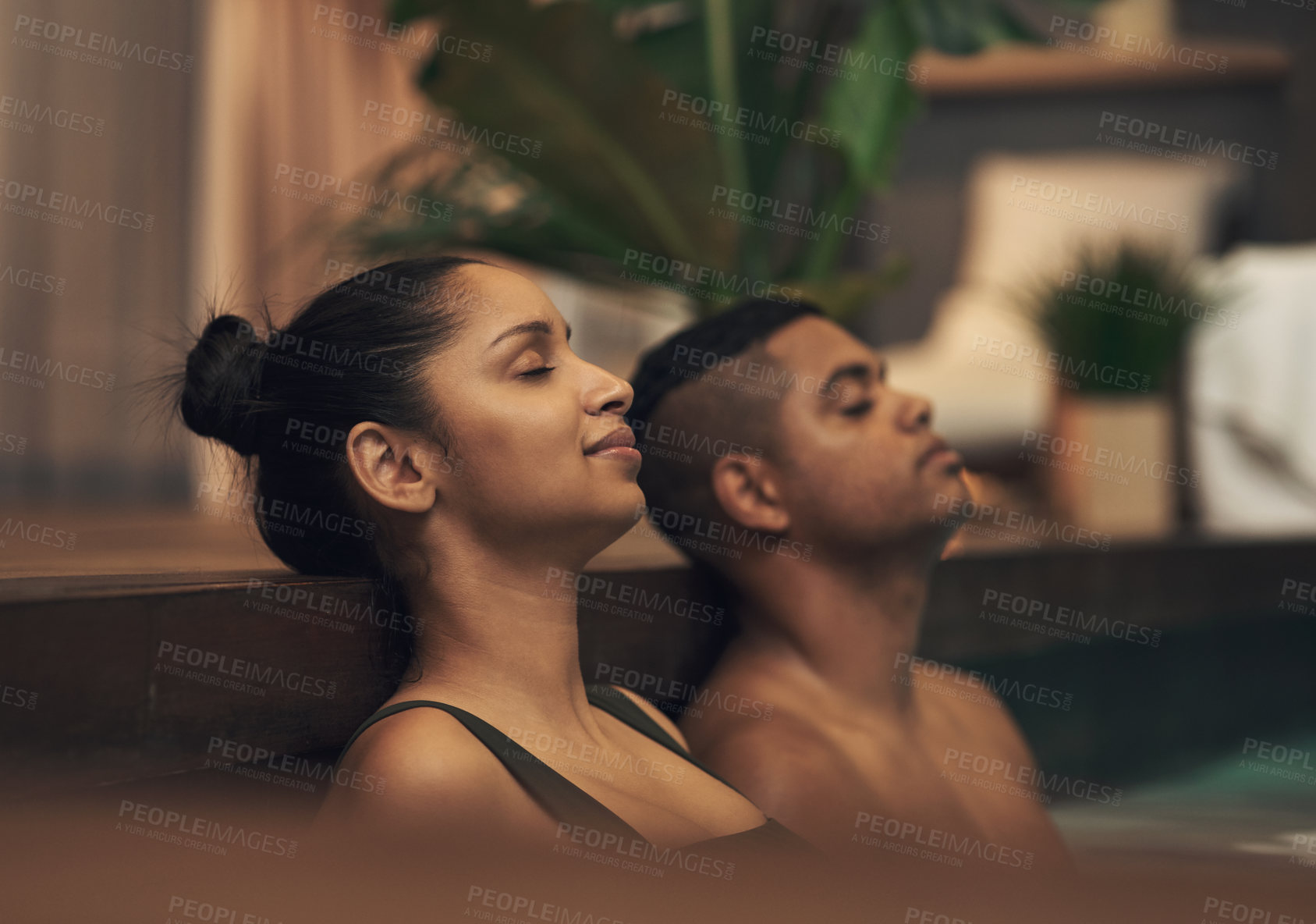 Buy stock photo Shot of a young couple relaxing in a pool at a spa