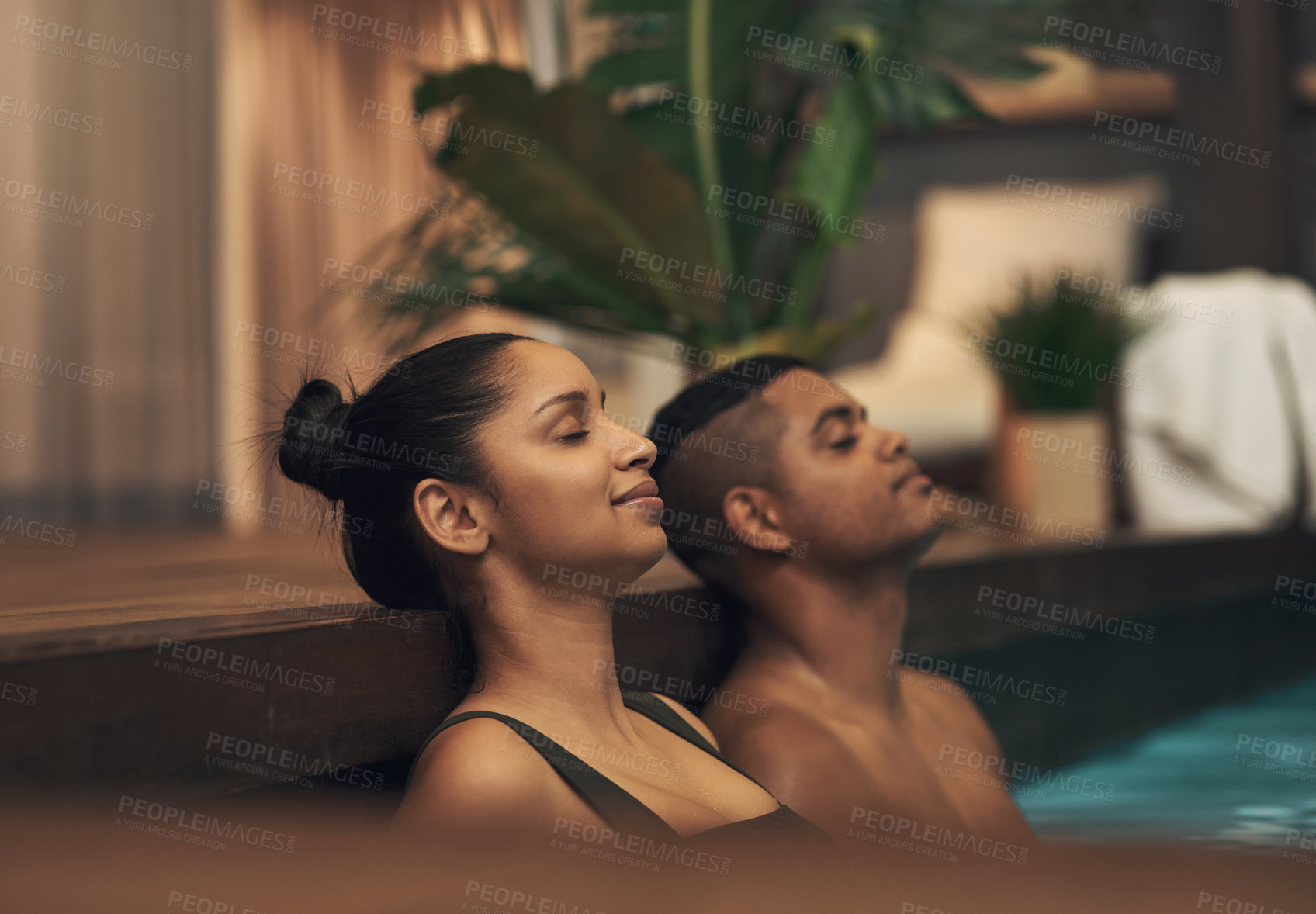 Buy stock photo Shot of a young couple relaxing in a pool at a spa