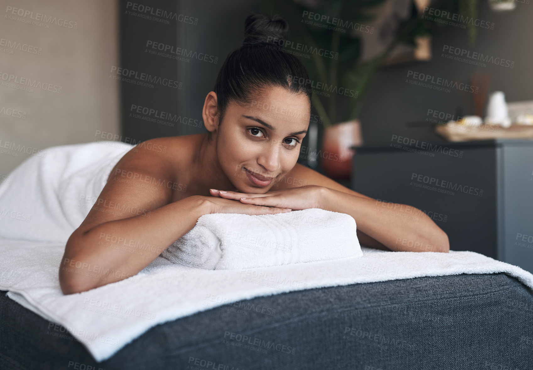 Buy stock photo Portrait of a young woman lying on a massage bed at a spa