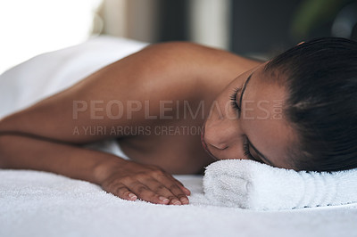 Buy stock photo Shot of a young woman lying on a massage bed at a spa