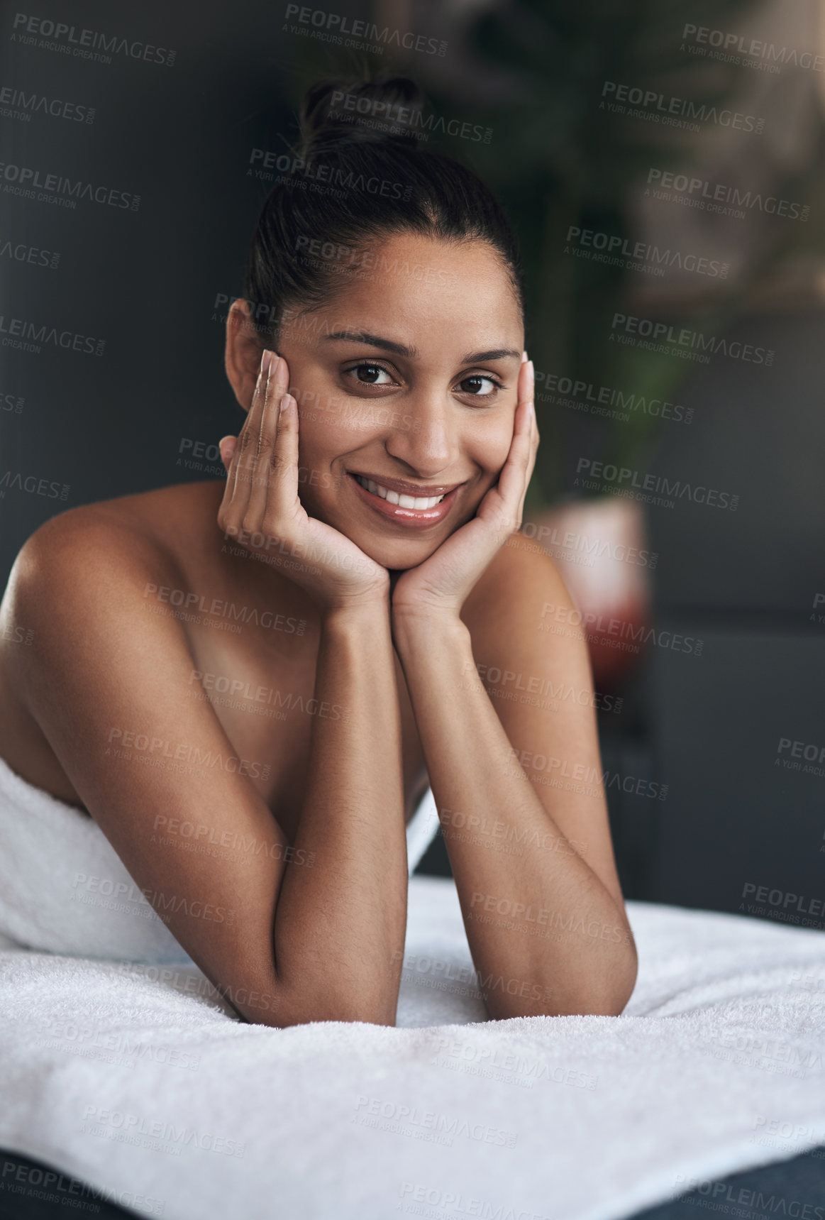 Buy stock photo Portrait of a young woman relaxing on a massage bed at a spa