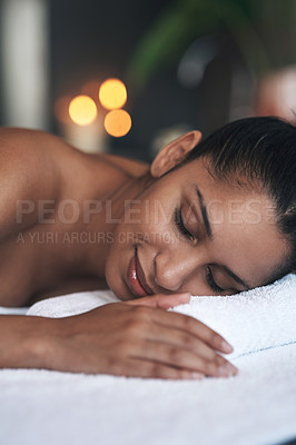 Buy stock photo Shot of a young woman lying on a massage bed at a spa