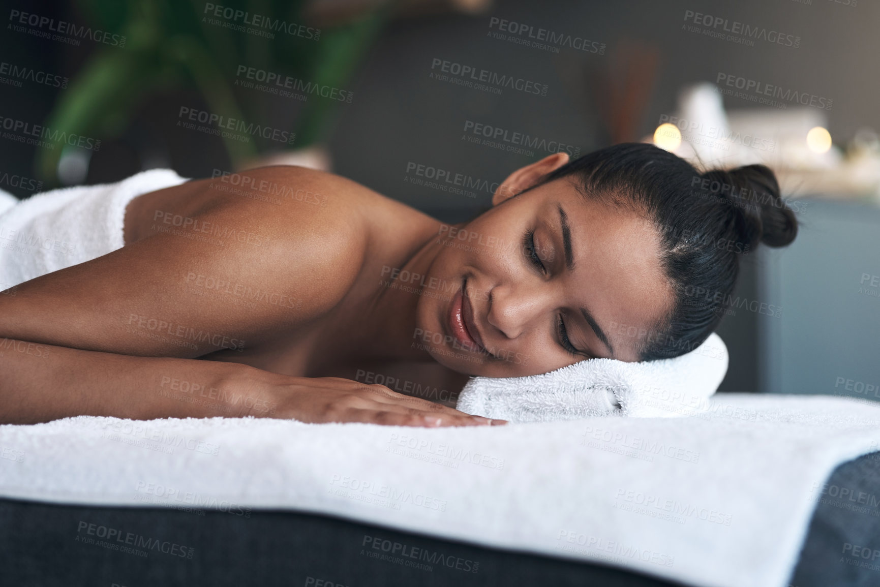 Buy stock photo Shot of a young woman lying on a massage bed at a spa