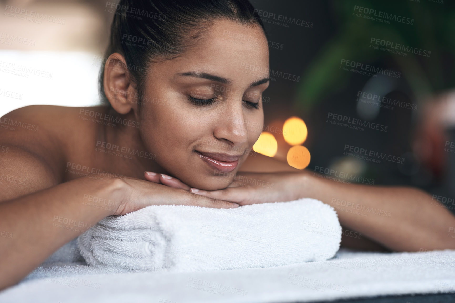 Buy stock photo Shot of a young woman lying on a massage bed at a spa